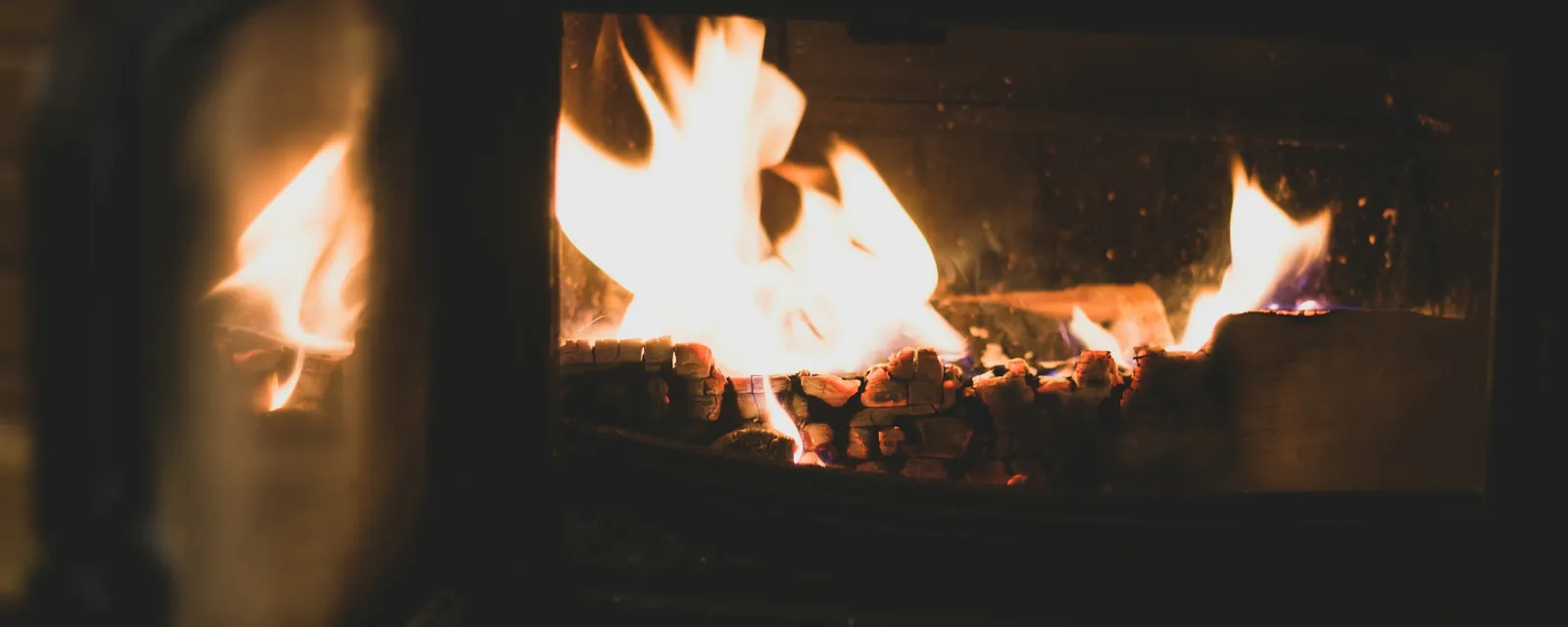 Flames behind the glass door of a wood stove